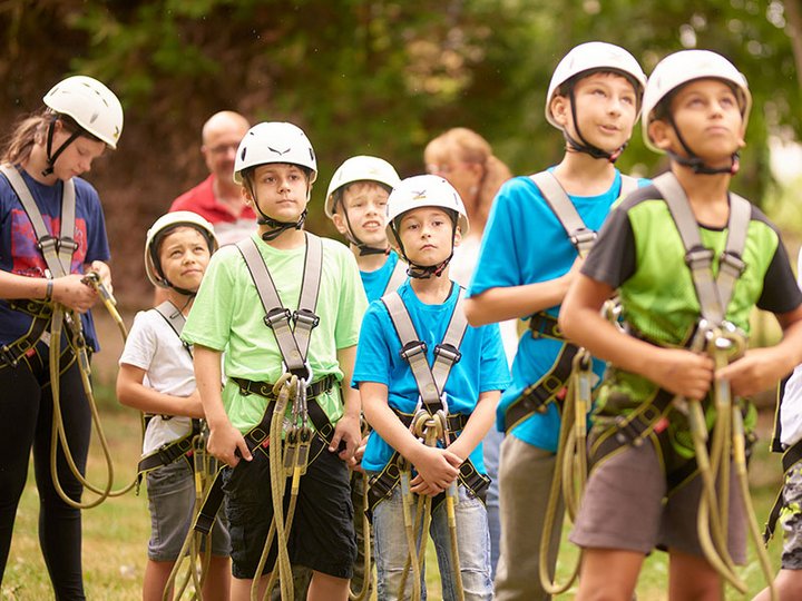 Kinder mit Kletterausrüstung: Helm, Seile, Gurt