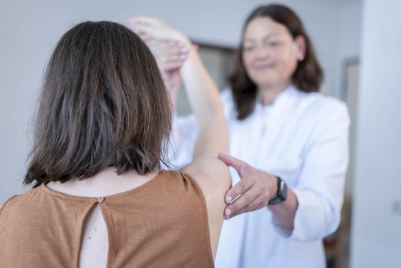 Orthopädin untersucht die Beweglichkeit der Schulter bei einer Patientin