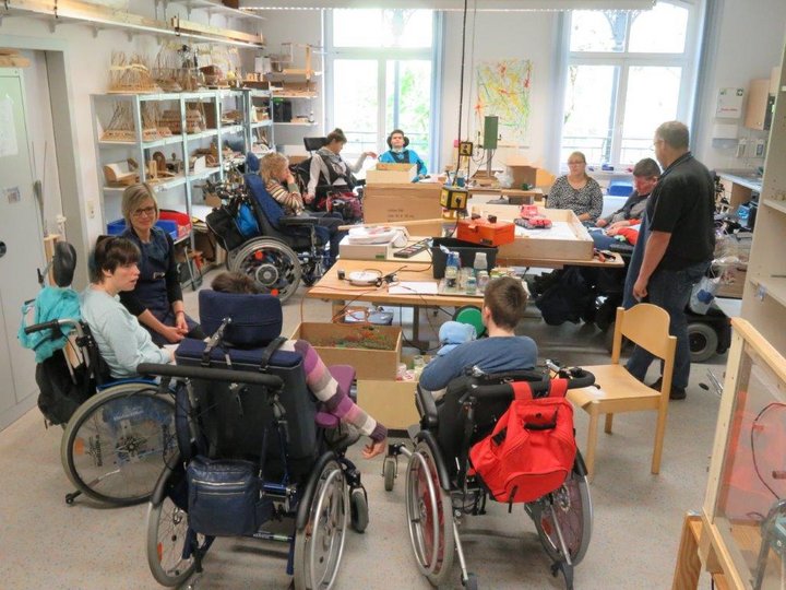 Menschen im Rollstuhl und Betreuer/-innen in der Tagesförderstätte Stiftung kreuznacher diakonie