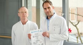 Chefarzt und Oberarzt zeigen Zertifikat des EndoProthetikZentrums