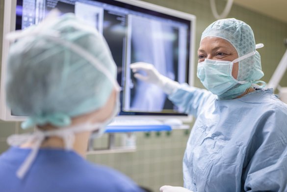 Ärzte schauen sich Röntgenbild eines verletzten Knies an