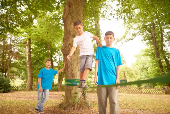 Jungs balancieren auf Slackline - Kinder-, Jugend- und Familienhilfe Niederwörresbach